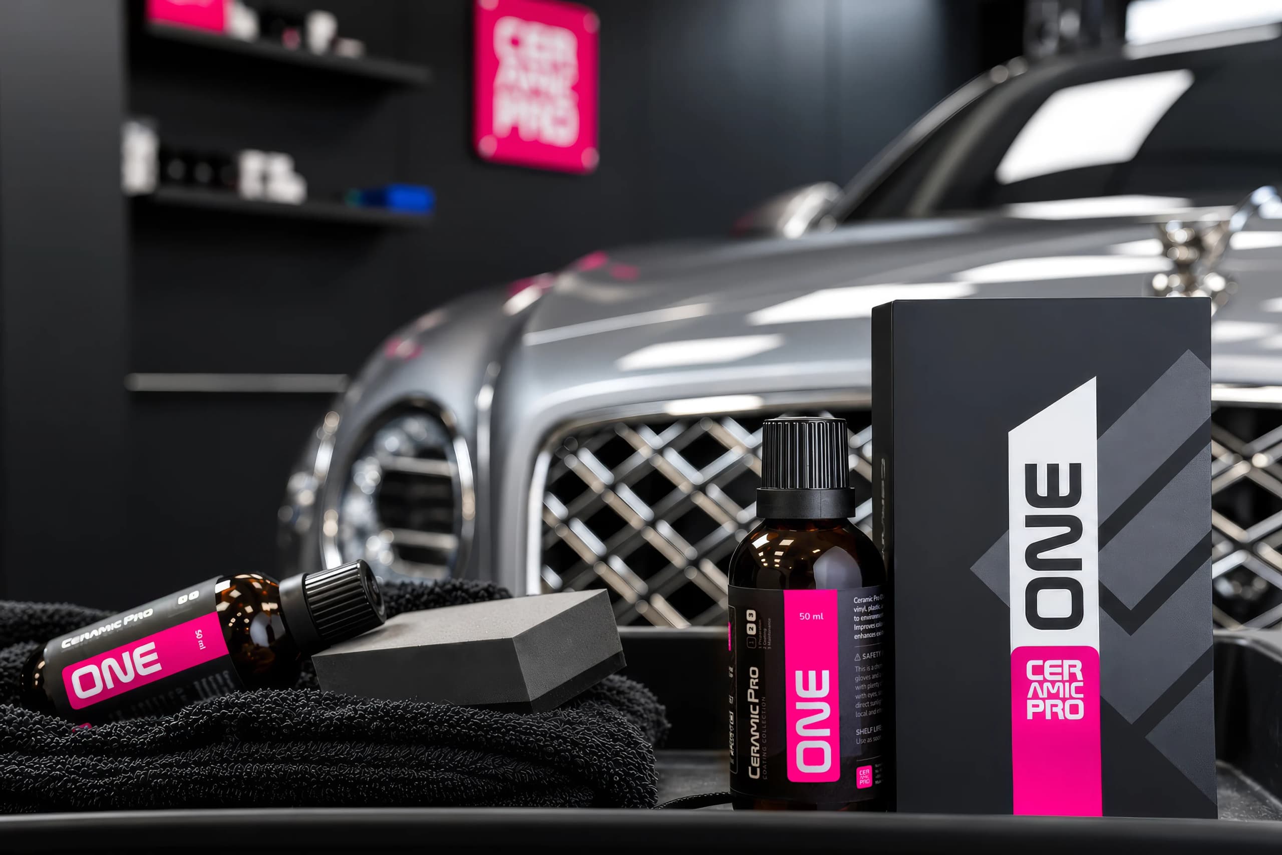 ONE kit with applicator and microfiber in front of a car in a Ceramic Pro studio